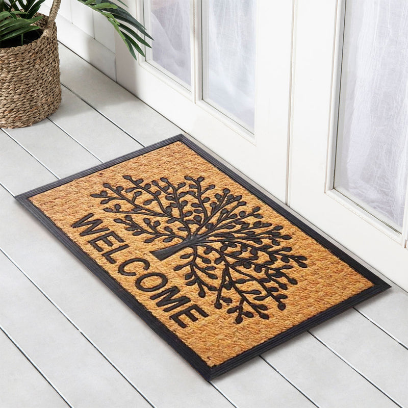 Doormat with 'Welcome' and tree design on a white wooden floor.