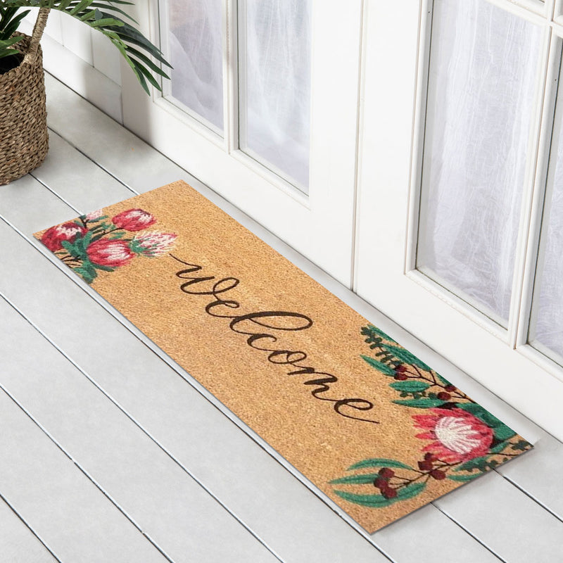 Doormat with floral design and 'welcome' text on a wooden floor.