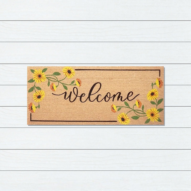 Doormat with 'Welcome' text and floral designs on a white wooden background